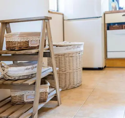 a wooden shelf with wicker baskets and a refrigerator at The Pearl Of Lozenets in Lozenets
