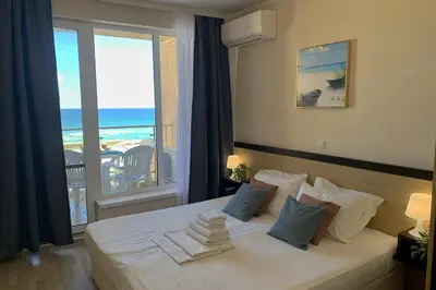 a bedroom with a bed with a view of the ocean at Apartments Obzor Beach C - Апартаменти Обзор Бийч С in Obzor