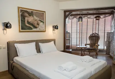 a bedroom with a bed and a chair and a table at Modern Comfort & Vintage Charm with Panoramic View by Flat Mаnаger in Varna City