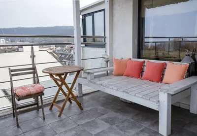 a bench on a balcony with a table and a chair at Modern Comfort & Vintage Charm with Panoramic View by Flat Mаnаger in Varna City