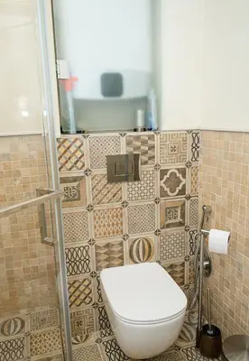 a bathroom with a toilet and a tiled wall at Modern Comfort & Vintage Charm with Panoramic View by Flat Mаnаger in Varna City