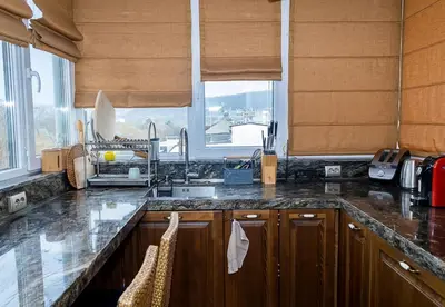 a kitchen with a counter and a sink and windows at Modern Comfort & Vintage Charm with Panoramic View by Flat Mаnаger in Varna City