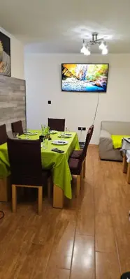 a dining room with a green table and a couch at Amara Butik on the first line in Ravda