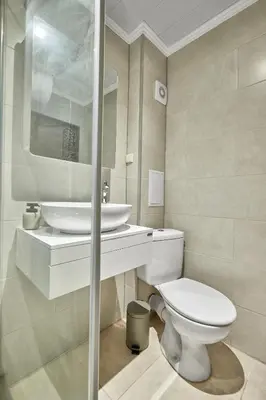 a bathroom with a white toilet and a sink at Beach Front Luxury Apartment in Sozopol