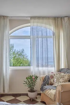 a living room with a couch and a large window at Beach Front Luxury Apartment in Sozopol