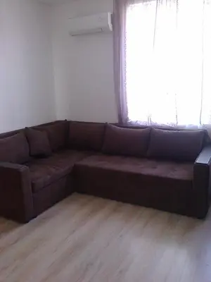 a brown couch in a living room with a window at Родина- Rey&Mar Apartment in Sveti Vlas