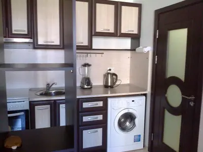 a small kitchen with a washing machine in it at Родина- Rey&Mar Apartment in Sveti Vlas