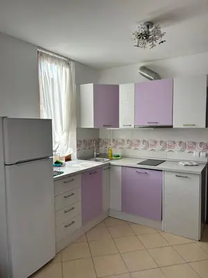 a kitchen with white appliances and purple cabinets at Апартамент в Риф 2 in Burgas City