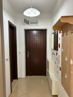 a kitchen with a brown door and a refrigerator at Апартамент в Риф 2 in Burgas City