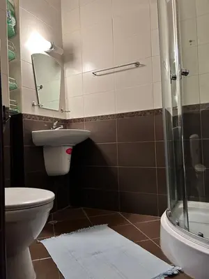 a bathroom with a toilet and a sink and a shower at Апартамент в Риф 2 in Burgas City