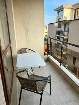 a balcony with a white table and two chairs at Апартамент в Риф 2 in Burgas City