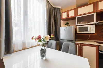 a kitchen with a vase of flowers on a table at Downtown Аpartment with Free Parking in Varna City