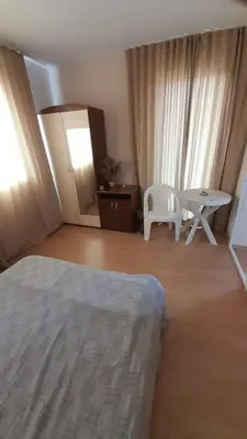 a bedroom with a bed and a table and a chair at Guest House Sveti Vlas in Sveti Vlas