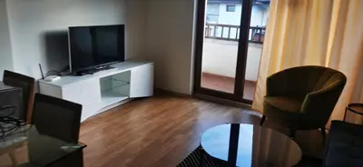 a living room with a flat screen tv and a chair at Nice 2 Bedroom Apartment with Sea and Poolview near Aheloy in Kableshkovo