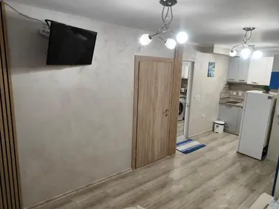 a room with a door and a television on a wall at Лукс Апартамент Морска Перла in Primorsko