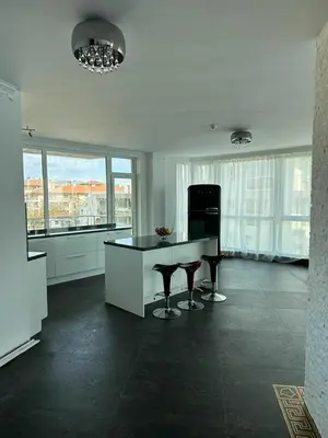 a kitchen with a table and chairs in a room with windows at Beach Front Luxurious Two Bedroom Apartment in Byala