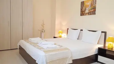 a bedroom with a bed with white sheets and pillows at Апартамент в непосредствена близост до плажа in Burgas City