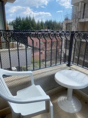 a white table and a chair on a balcony at Apartment at Royal Sun, Sunny Beach in Sunny Beach