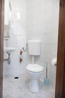 a white bathroom with a toilet and a sink at Lidia Odrin by RV Apartments in Varna City