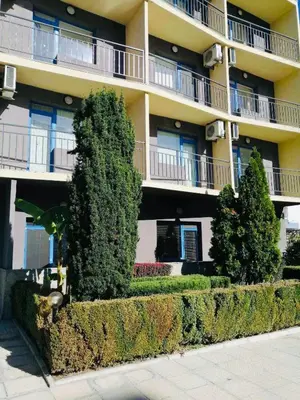 an apartment building with bushes in front of it at Jasmine A17 Cozy Studio Sunny Beach in Sunny Beach