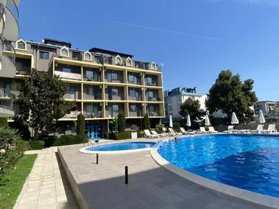 a hotel with a swimming pool in front of a building at Jasmine A17 Cozy Studio Sunny Beach in Sunny Beach