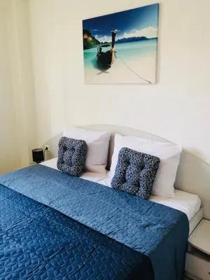 a bed with a blue blanket and pillows on it at Jasmine A17 Cozy Studio Sunny Beach in Sunny Beach