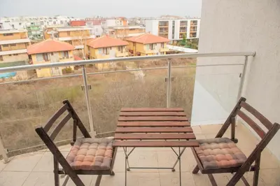 a balcony with a wooden table and two chairs at Atlantis Resort Private 1BD apart by Flat Mаnager in Burgas City