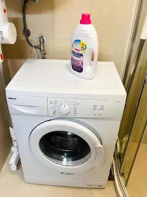 a bottle of laundry detergent sitting on top of a washing machine at La Dahlia studio - Cascadas family resort in Sunny Beach