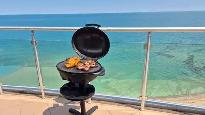 a grill on a balcony with a view of the ocean at Amazing panorama sea view apartment in Byala