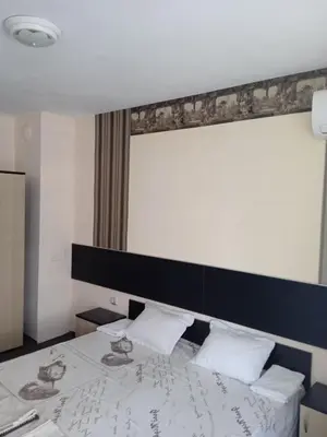 a bedroom with a bed with a black headboard at Къща за гости дани in Primorsko