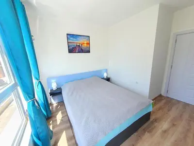 a small bedroom with a bed and a window at Neptun-Blue in Primorsko
