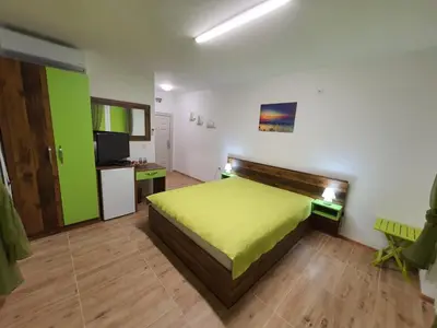 a bedroom with a bed and a desk and a television at Neptun-Green in Primorsko