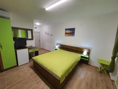 a bedroom with a green bed and a television at Neptun-Green in Primorsko
