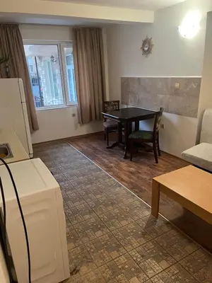 a living room with a table and a couch at Хотел Стоянови in Ravda