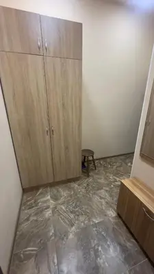 an empty room with wooden cabinets and a tiled floor at Studio paradise in Varna City