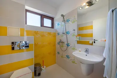 a bathroom with a sink and yellow and white stripes at Апартаменти с чадъри и шезлонги на плажа - Свети Никола Каваците in Sozopol