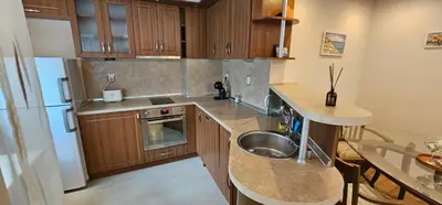 a kitchen with a sink and a stainless steel refrigerator at Rada's Apartment BSV in Burgas City