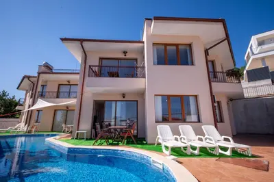a villa with a swimming pool in front of a house at Villa Belissima in Sveti Vlas