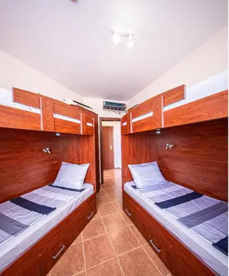 two beds in a room with wooden walls at Villa Belissima in Sveti Vlas