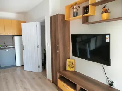 a living room with a flat screen tv on a wall at Star Beach - Звезден плаж in Primorsko