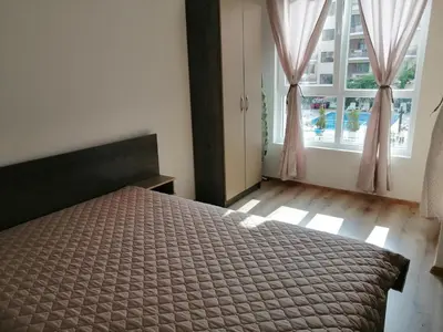 a bedroom with a bed and a large window at Star Beach - Звезден плаж in Primorsko