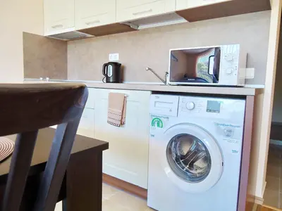 a kitchen with a washing machine and a microwave at Oxygen Apartments in Sveti Vlas