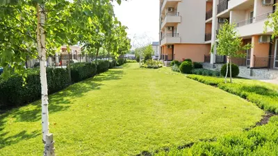 a green lawn in front of a building at Oxygen Apartments in Sveti Vlas