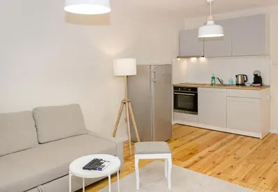 a living room with a couch and a table and a kitchen at Cozy & Functional by the Opera in Varna City