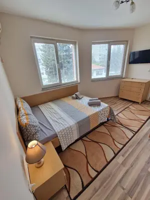 a bedroom with a bed and two windows at Lazur Sea Garden 2 in Burgas City