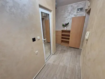 a hallway with a door and a cabinet in a room at Lazur Sea Garden 2 in Burgas City