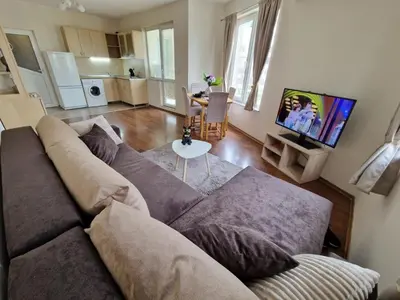 a living room with a couch and a tv at Lazur Sea Garden 2 in Burgas City