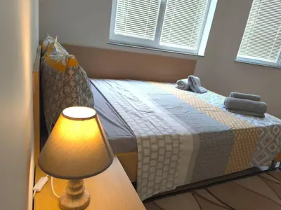 a bedroom with a bed with a lamp next to it at Lazur Sea Garden 2 in Burgas City
