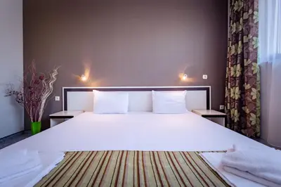 a bedroom with a large bed with white sheets and pillows at Hotel Oasis Del Mare in Lozenets
