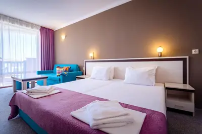 a bedroom with a large bed with towels on it at Hotel Oasis Del Mare in Lozenets